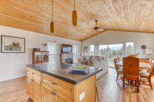 a kitchen and living room with a wooden ceiling at Riveredge Retreat in Seaside
