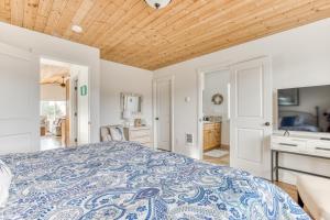 um quarto com uma cama com uma colcha azul e branca em Riveredge Retreat em Seaside