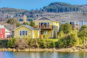 a yellow house on the shore of a body of water at Riveredge Retreat in Seaside