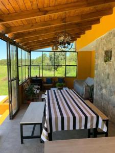a patio with a table and a couch and windows at Las Tres Rosas Casa de Campo in Falda del Carmen