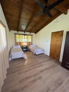 a large room with two beds and a wooden ceiling at Las Tres Rosas Casa de Campo in Falda del Carmen