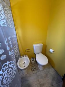 Falda del Carmen的住宿－Las Tres Rosas Casa de Campo，黄色的浴室设有卫生间和水槽
