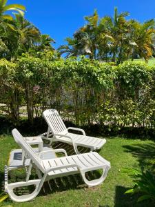 dos sillas blancas de césped sentadas en el césped en Gîte Zandoli Koko, en Sainte-Anne