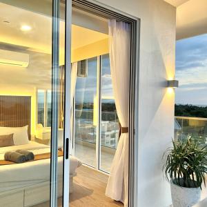 a bedroom with a view of a bed and a balcony at AruSuites Tanjung Aru Kota Kinabalu - Laxzone Suite in Kota Kinabalu