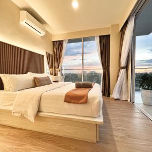 a bedroom with a large bed with a large window at AruSuites Tanjung Aru Kota Kinabalu - Laxzone Suite in Kota Kinabalu