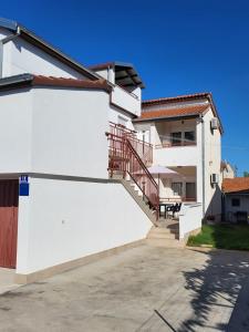 Una casa blanca con una escalera en el lateral. en Apartments with a parking space Valbandon, Fazana - 15386, en Fažana