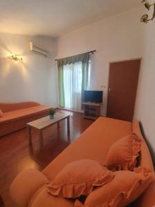 ein Wohnzimmer mit einem orangenen Sofa und einem Tisch in der Unterkunft Apartments with a parking space Valbandon, Fazana - 15386 in Fažana