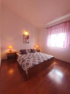 ein Schlafzimmer mit einem Bett, einem Fenster und zwei Lampen in der Unterkunft Apartments with a parking space Valbandon, Fazana - 15386 in Fažana