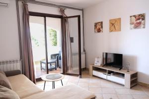 ein Wohnzimmer mit einem Sofa und einem TV in der Unterkunft Apartments by the sea Prigradica, Korcula - 20608 in Blato