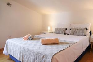 ein Schlafzimmer mit einem großen weißen Bett mit zwei Kissen darauf in der Unterkunft Apartments by the sea Prigradica, Korcula - 20608 in Blato
