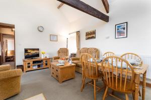 a living room with a table and chairs and a couch at Bwthyn Llys Twrog in Moel-tryfan