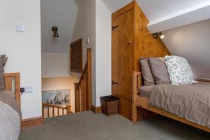 a bedroom with a bed with a wooden wall at Bwthyn Llys Twrog in Moel-tryfan