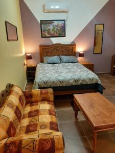 1 dormitorio con 1 cama y 1 sofá en Suites de Mita - Boutique Hotel en Punta Mita