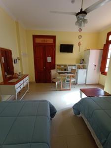 a living room with a bed and a table and a kitchen at Hostal Virgen del Rosario Cafayate in Cafayate