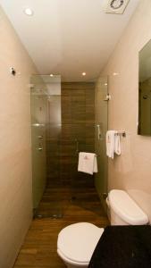 a bathroom with a toilet and a glass shower at Hotel El Conde Naucalpan Only Adults in Mexico City +13 photos