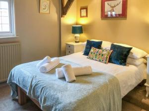 a bedroom with a bed with towels on it at Beehive Cottage in Wittersham