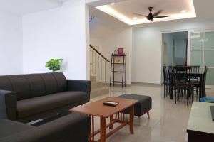 uma sala de estar com um sofá e uma mesa em Desaru Nova Guest House with BBQ and Near Tanjung Balau Beach em Bandar Penawar