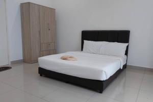 um quarto com uma cama grande e uma cabeceira preta em Desaru Nova Guest House with BBQ and Near Tanjung Balau Beach em Bandar Penawar