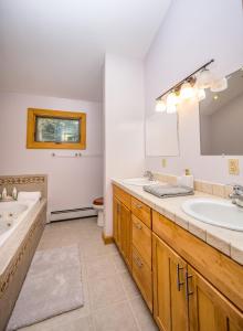 baño con 2 lavabos y espejo grande en Beautiful Chalet, mins to Hunter/Windham slopes, en Jewett