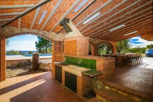 a patio with an outdoor kitchen and a table at Aliga Villa in Alcover