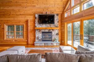 a living room with a fireplace and a tv at Beautiful Chalet, mins to Hunter/Windham slopes in Jewett