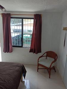 - une chambre avec un lit, une chaise et une fenêtre dans l'établissement Sandy's room, à Cancún