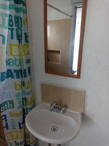 a bathroom with a sink and a mirror at Sandy's room in Cancún