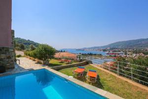 Skiathos Seaview Villa with Pool في Punta: مسبح مع كراسي وإطلالة على الماء