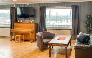 - un salon avec un piano et une chaise dans l'établissement Awesome Apartment In Mesnali With House A Panoramic View, à Mesnali