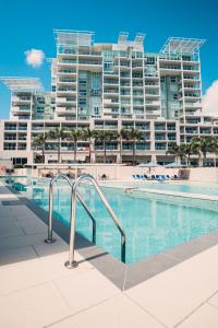 a swimming pool in front of a large apartment building at Pelican Waters Golf Resort in Caloundra