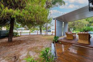 a wooden deck with two chairs and a tree at 200m to Tallebudgera Creek - Hosted by Burleigh Letting in Gold Coast