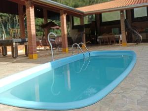 a large blue swimming pool on a patio at Recanto Quina da Mata in Santo Antônio do Pinhal +28 photos