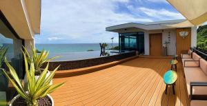 a house with a deck with a view of the ocean at Kenting Sand Island W-Villa Seaview Resort in Fan-tzu-liao