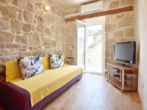 un soggiorno con divano giallo e TV di Apartments Nada a Spalato (Split)
