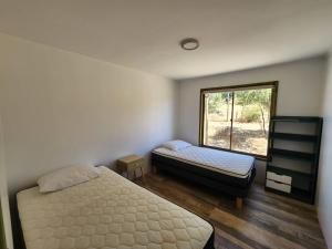 sypialnia z 2 łóżkami i oknem w obiekcie Parcela Lago Rapel 