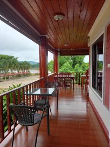 a porch with tables and chairs on a balcony at Welcome holiday in Chiang Khan