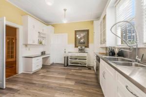 a kitchen with white cabinets and a sink at The Gauthier House Downtown Lafayette Louisiana in Lafayette +21 photos