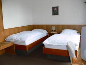 two twin beds in a room with two night stands at Zentral Hotel Poststuben in Krefeld