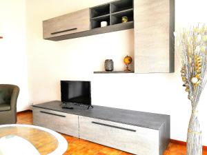 ein Wohnzimmer mit einem Entertainment-Center mit einem TV in der Unterkunft Novara Suite in Novara