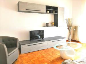 ein Wohnzimmer mit einem TV und einem Glastisch in der Unterkunft Novara Suite in Novara