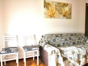 ein Wohnzimmer mit einem Sofa und 2 Stühlen in der Unterkunft Novara Suite in Novara