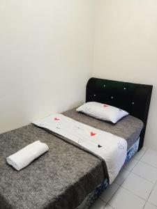 ミリにあるA&W Homestay, Vista Perdana, Miriの白い壁のベッドルーム1室(ツインベッド2台付)