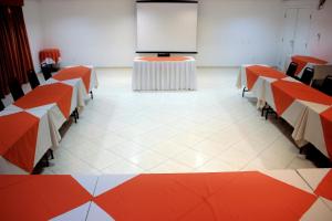 a conference room with tables and a projection screen at Harbor Self Graciosa Hotel in Quatro Barras