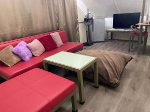 a living room with a red couch and a table at D'Schnuggs Place in Panglao Island