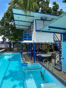 a pool with a table and chairs next to a building at D'Schnuggs Place in Panglao Island