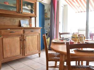 uma sala de jantar com uma mesa e um armário de madeira em Appartement Gruissan, 2 pièces, 4 personnes - FR-1-229-788 em Gruissan