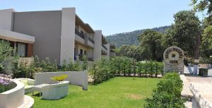 a building with a yard in front of a building at Santa Helena Hotel in Ialyssos