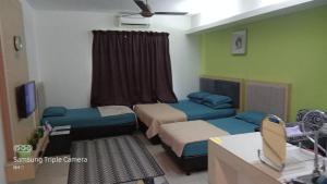 een kleine kamer met 2 bedden en een raam bij NH Studio Apartment Homestay in Wakaf Che Yeh