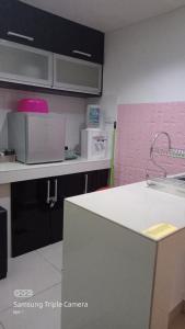 uma cozinha com um lavatório e uma bancada em NH Studio Apartment Homestay em Wakaf Che Yeh