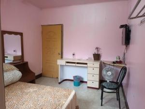 a bedroom with a desk and a chair and a mirror at Ruishi Homestay in T'ai-ping